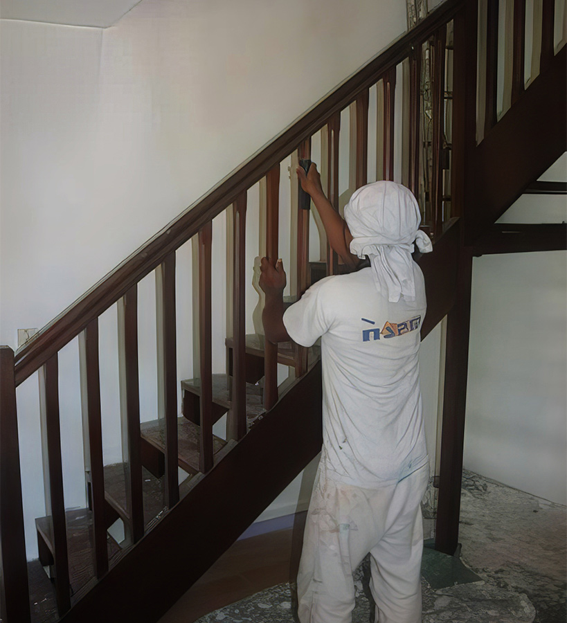 Peintre de SASU Maleau qui vernit le bois d'un escalier en martinique